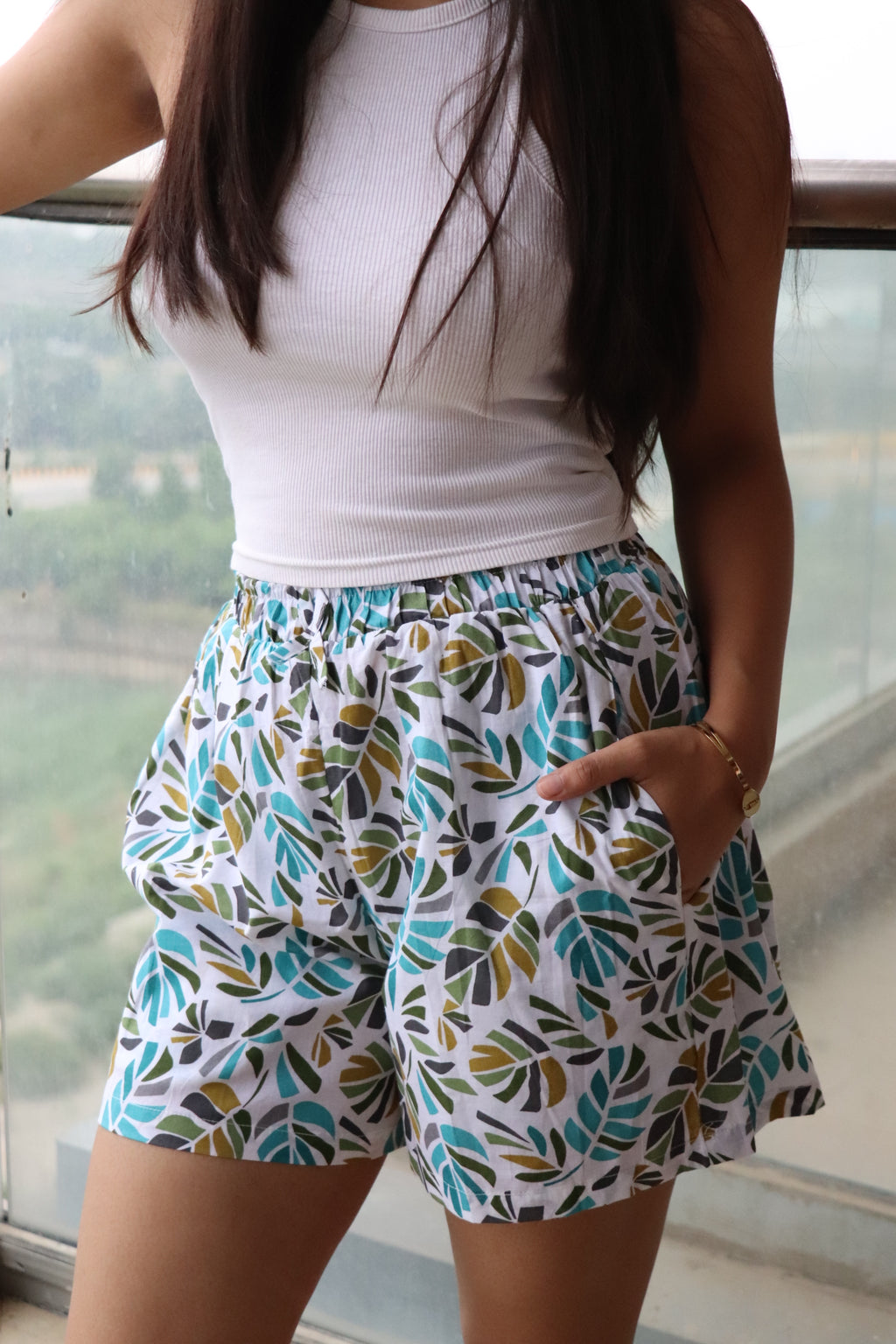 Leaves printed cotton shorts with elastic waistband and pockets, perfect for lounging or sleepwear.